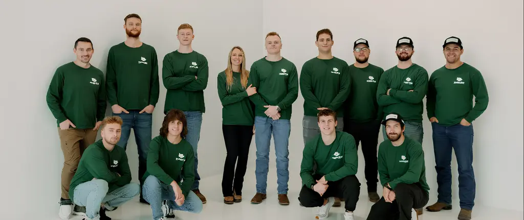 Team Photo With Green Woolley Bros Lawn Care Uniform